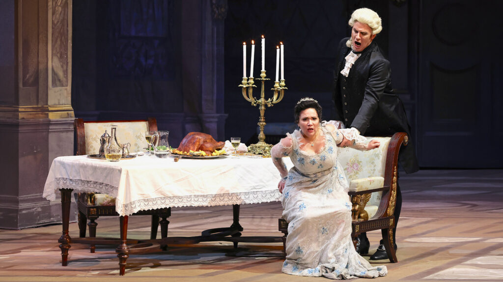 Carmen Giannattasio e Lucas Meachem intorno a una tavola imbandita con al centro un candeliere